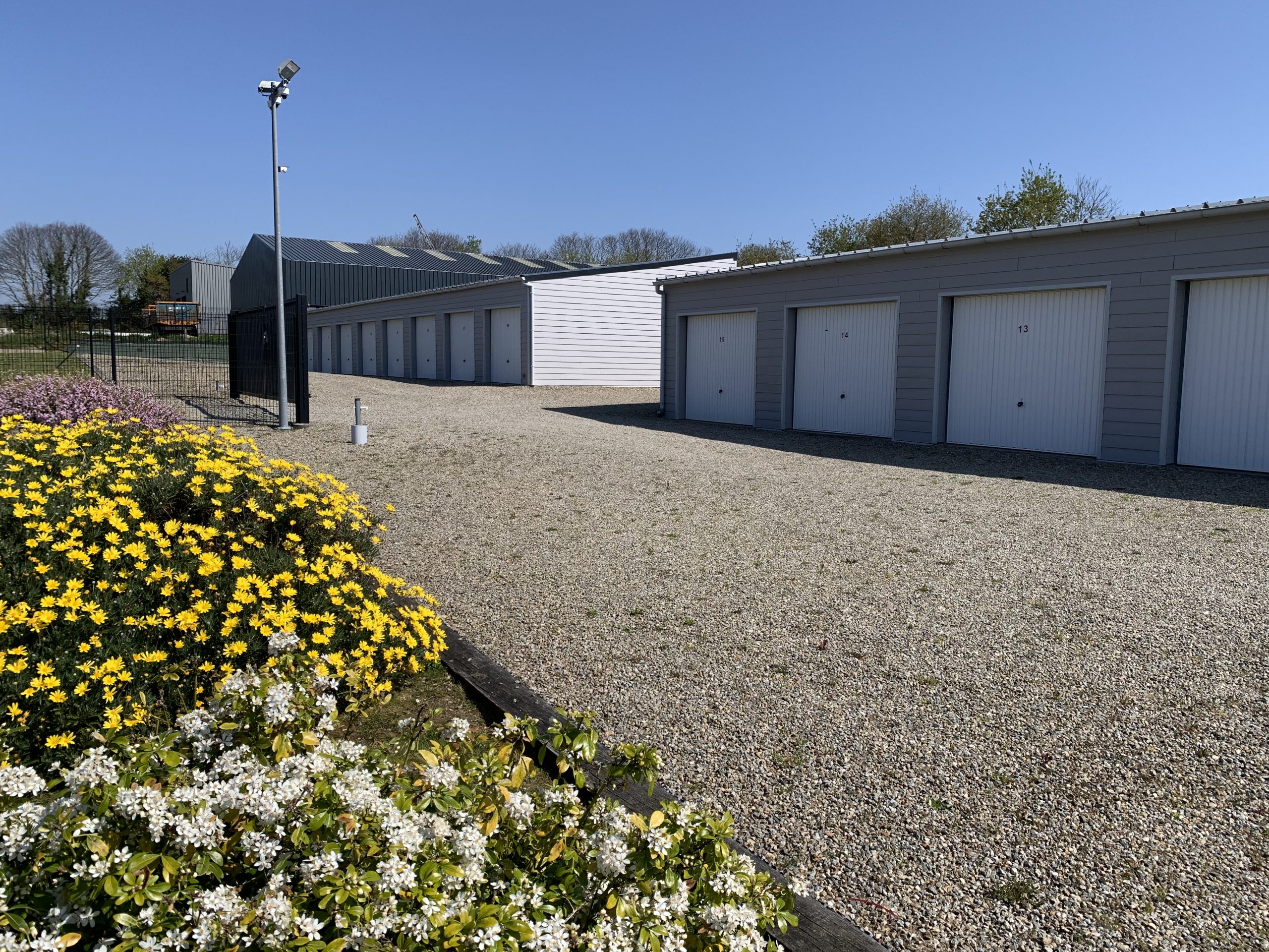 Photo des garages et de l'allée fleurie louebox29 Louebox29 location de solution de stockage à Fouesnant