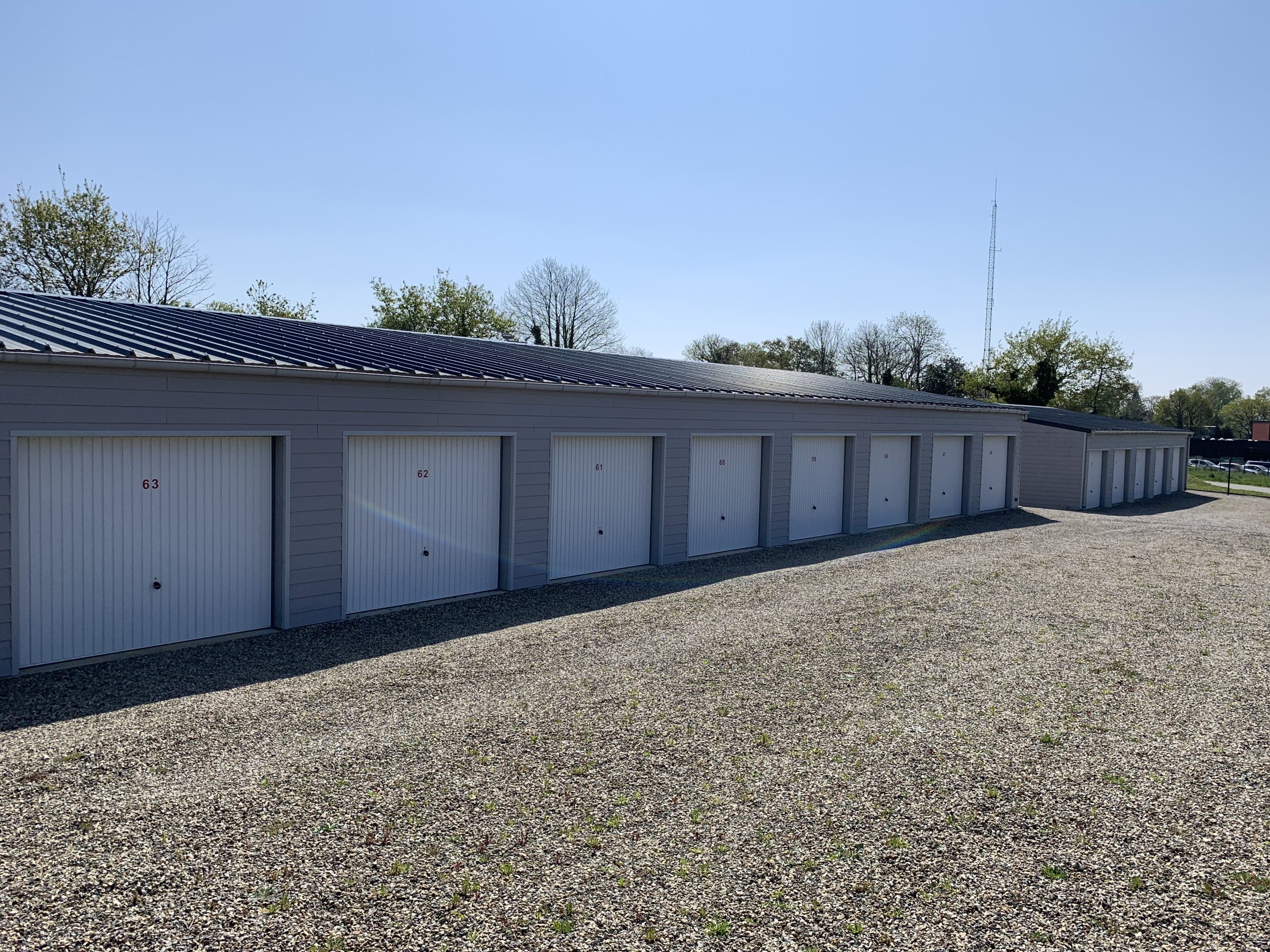 Photo de l'allée avec des garages de stockage à gauche. Louebox29 location de solution de stockage à Fouesnant